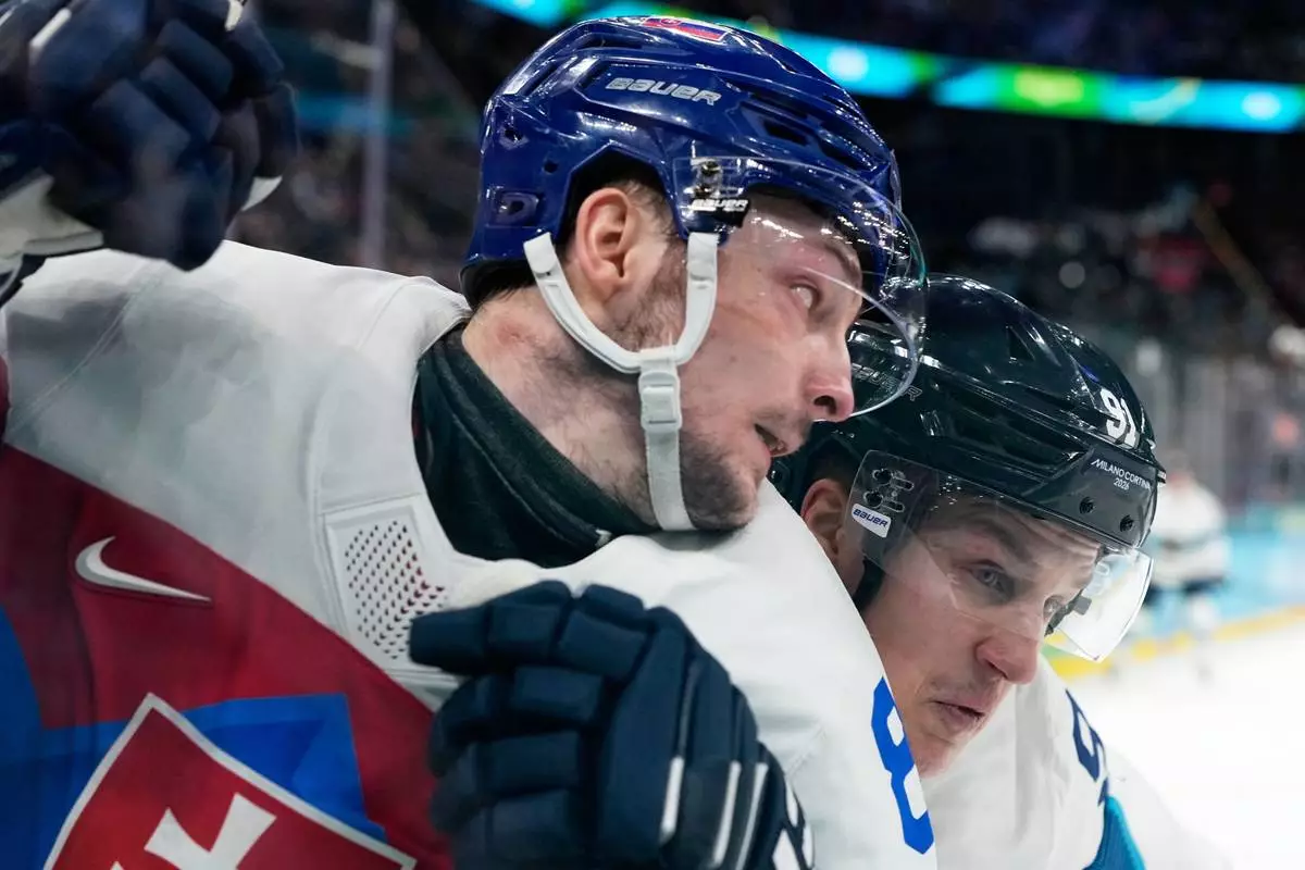 Slovakia's Oliver Okuliar (8) challenges with Finland's Oliver Kapanen (91) during a men's ice hockey bronze medal game between Slovakia and Finland at the 2026 Winter Olympics, in Milan, Italy, Saturday, Feb. 21, 2026. (AP Photo/Hassan Ammar)