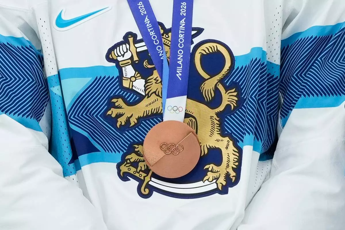 Finland's Artturi Lehkonen is decorated with bronze medal during victory ceremony after a men's ice hockey bronze medal game between Slovakia and Finland at the 2026 Winter Olympics, in Milan, Italy, Saturday, Feb. 21, 2026. (AP Photo/Hassan Ammar)