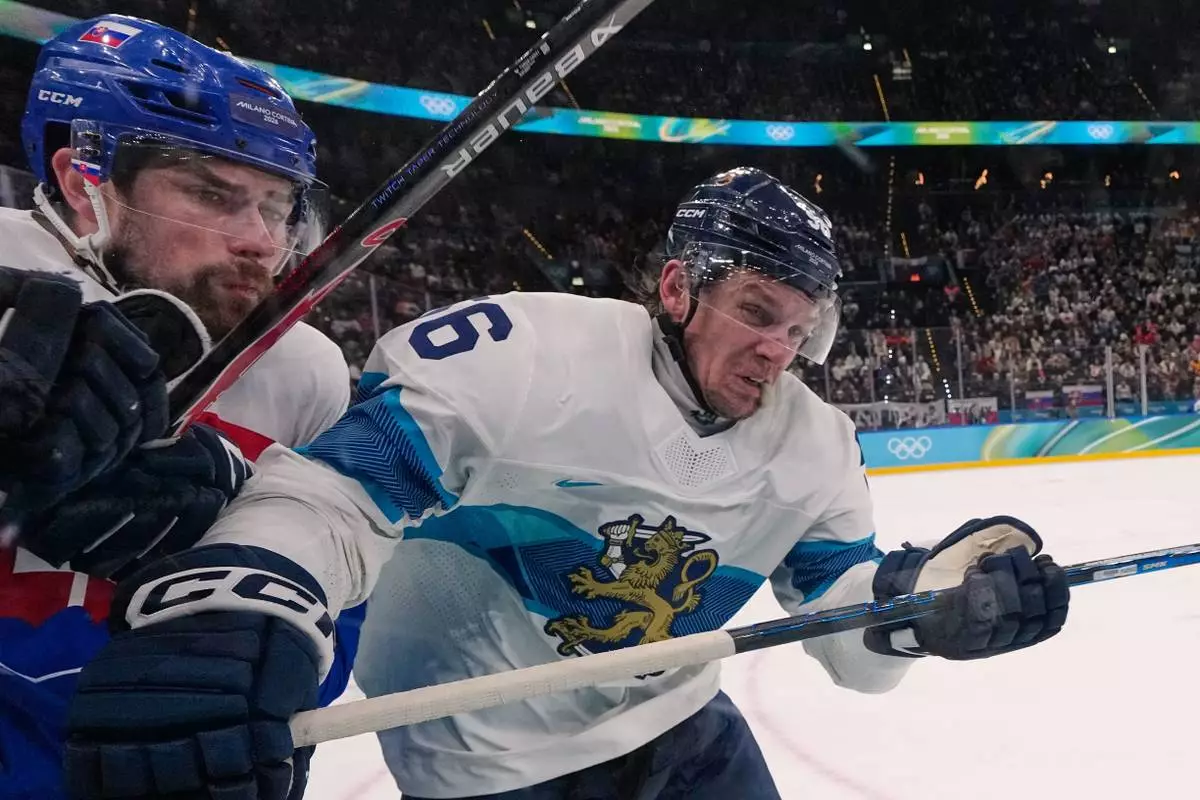 Finland's Erik Haula (56) slams Slovakia's Peter Ceresnak, left, against the boards during a men's ice hockey bronze medal game between Slovakia and Finland at the 2026 Winter Olympics, in Milan, Italy, Saturday, Feb. 21, 2026. (AP Photo/Petr David Josek)