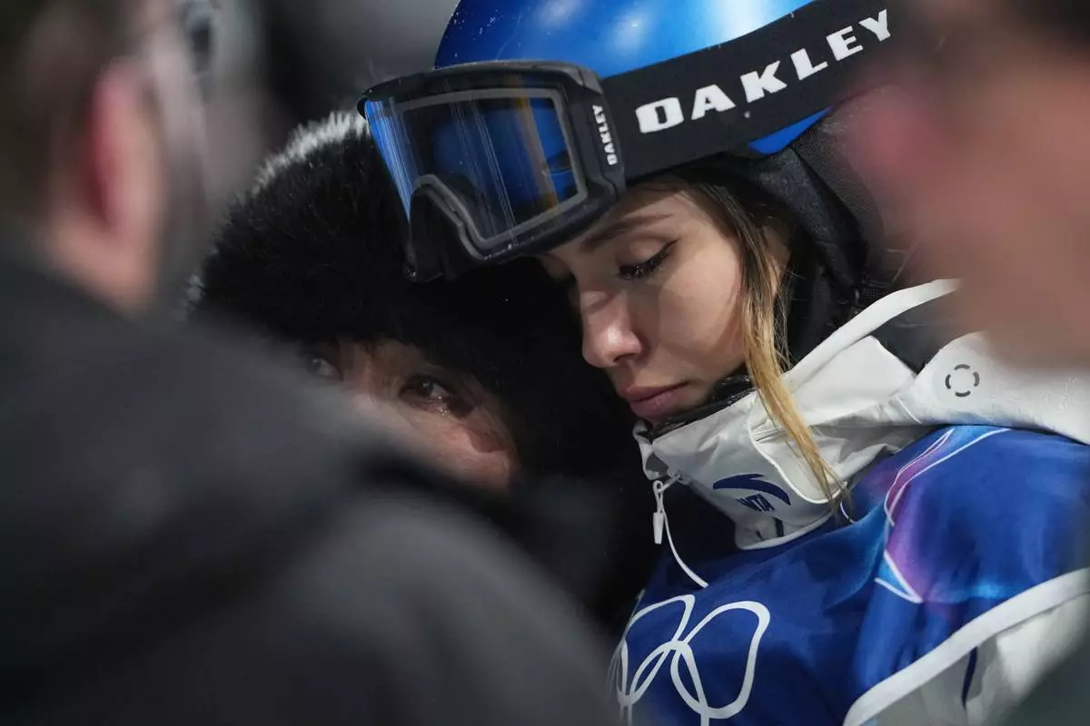 China's Eileen Gu, right, reacts alongside her mother, Yan Gu, after Canada's Cassie Sharpe crashed during the women's freestyle skiing halfpipe qualifications at the 2026 Winter Olympics, in Livigno, Italy, Thursday, Feb. 19, 2026. (AP Photo/Lindsey Wasson)