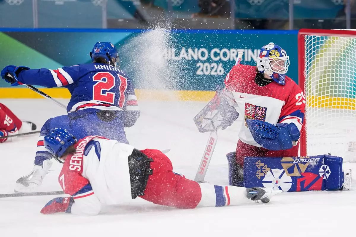 Czechia's Klara Seroiszkova slides into Czechia's Klara Peslarova, right, as United States' Hilary Knight scores her sides fourth goal during a preliminary round match of women's ice hockey between United States and Czechia at the 2026 Winter Olympics, in Milan, Italy, Thursday, Feb. 5, 2026. (AP Photo/Petr David Josek)