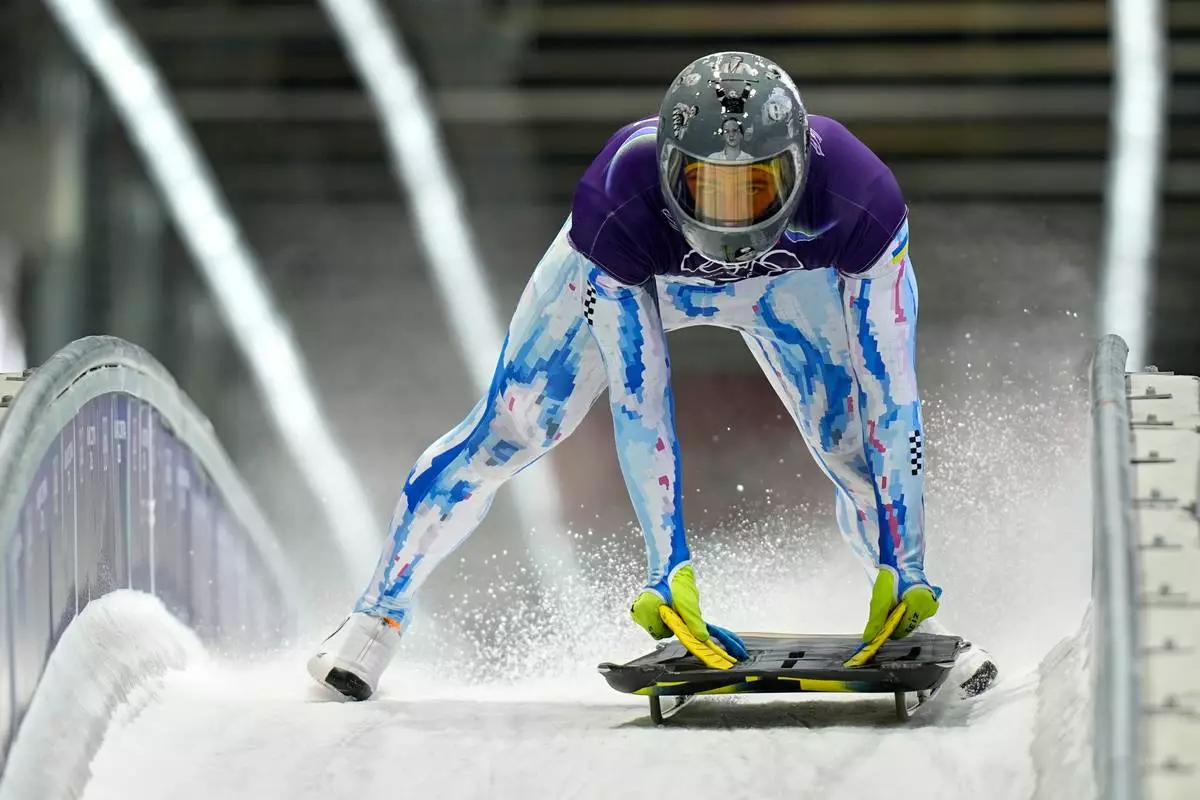 Ukraine's Vladyslav Heraskevych arrives at the finish during a men's skeleton training session at the 2026 Winter Olympics, in Cortina d'Ampezzo, Italy, Monday, Feb. 9, 2026. (AP Photo/Aijaz Rahi)