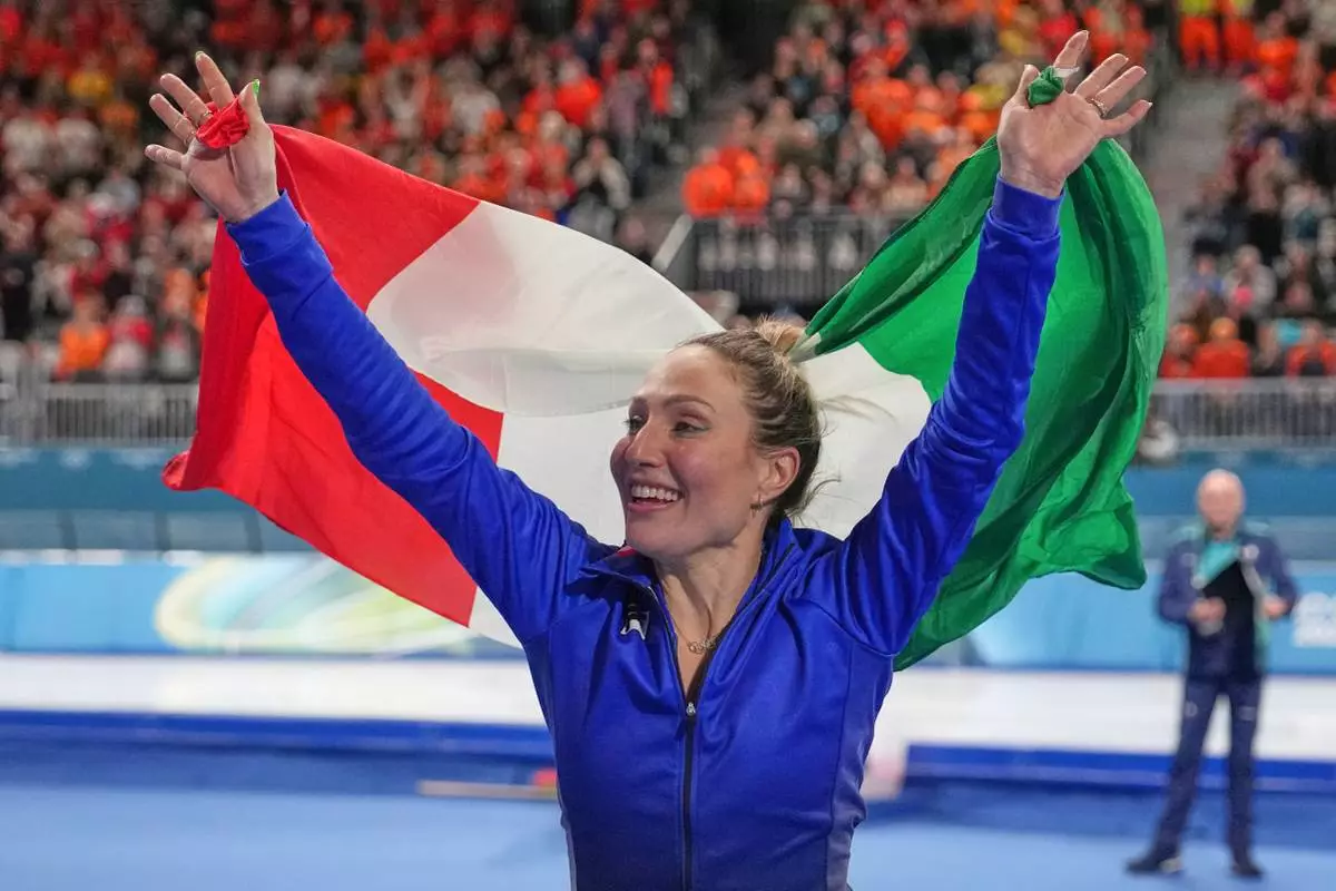Gold medallist Francesca Lollobrigida of Italy celebrates with the Italian flag after the women's 3,000 meters speedskating race at the 2026 Winter Olympics, in Milan, Italy, Saturday, Feb. 7, 2026. (AP Photo/Christophe Ena)