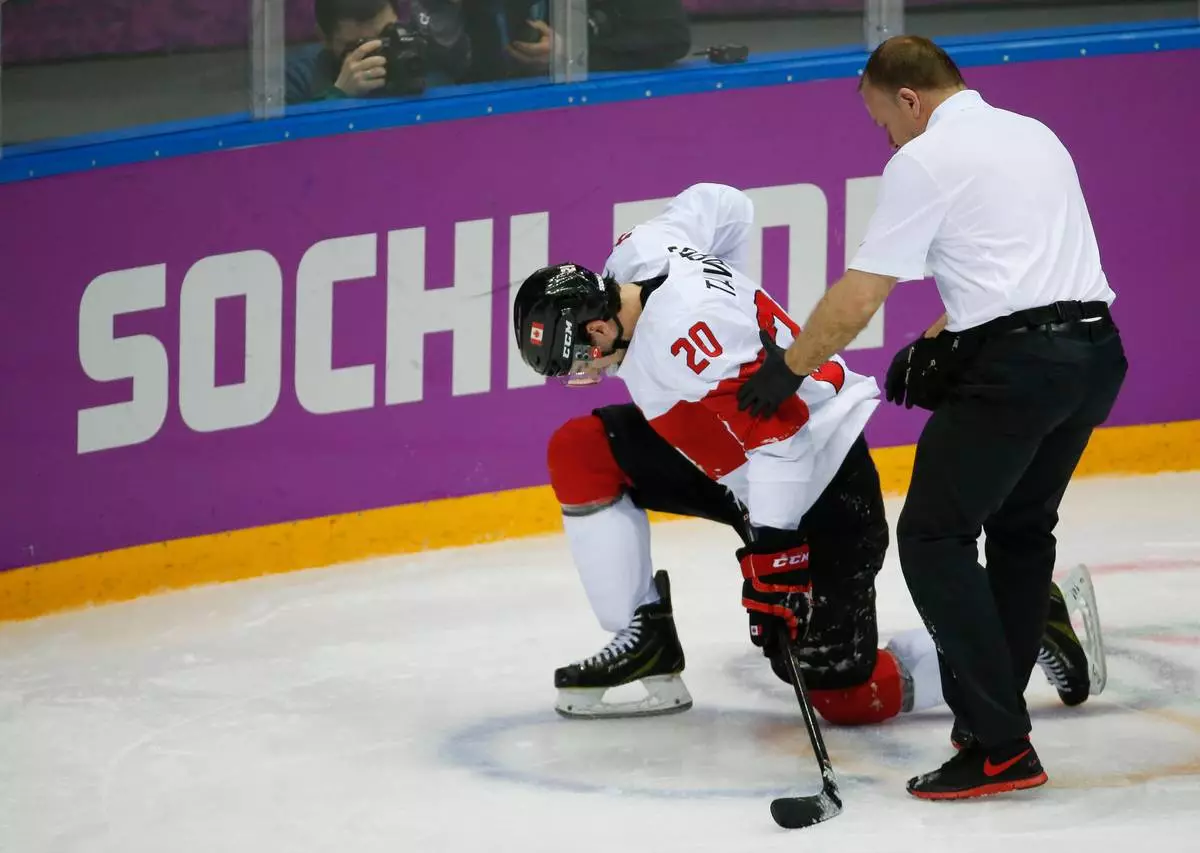 FILE - Canada forward John Tavares is helped up off the ice by a trainer during the second period of a men's quarterfinal ice hockey game against Latvia at the 2014 Winter Olympics, Wednesday, Feb. 19, 2014, in Sochi, Russia. (AP Photo/Mark Humphrey, File)
