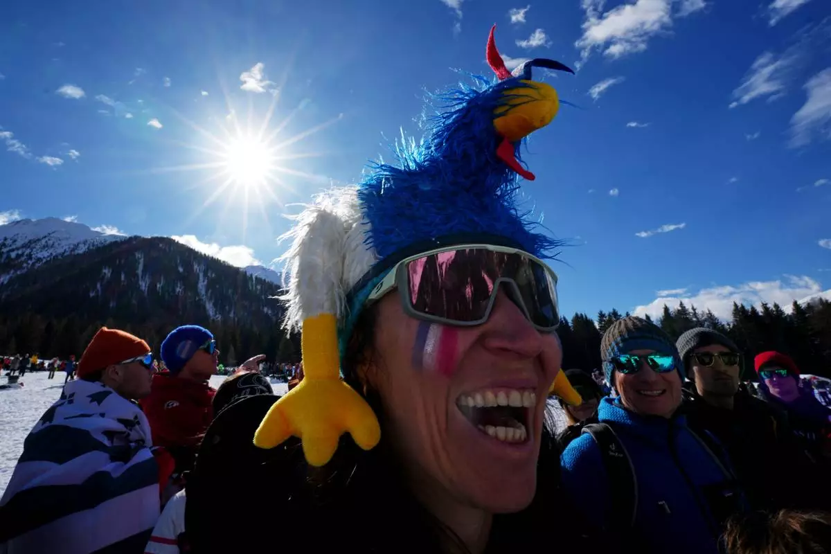 A fan of France waits for the start of the men's 15-kilometer mass start biathlon race at the 2026 Winter Olympics in Anterselva, Italy, Friday, Feb. 20, 2026. (AP Photo/Andrew Medichini)