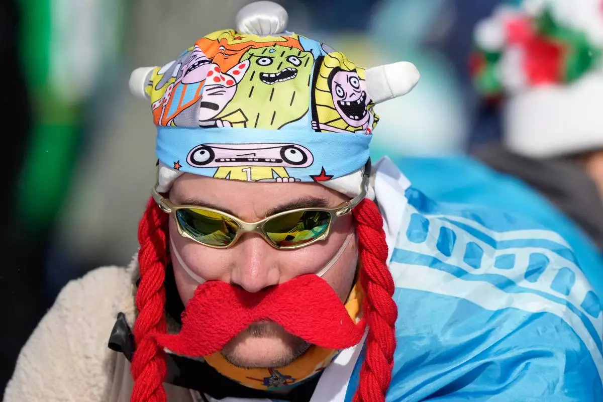 A fan attends the men's 15-kilometer mass start biathlon race at the 2026 Winter Olympics in Anterselva, Italy, Friday, Feb. 20, 2026. (AP Photo/Mosa'ab Elshamy)
