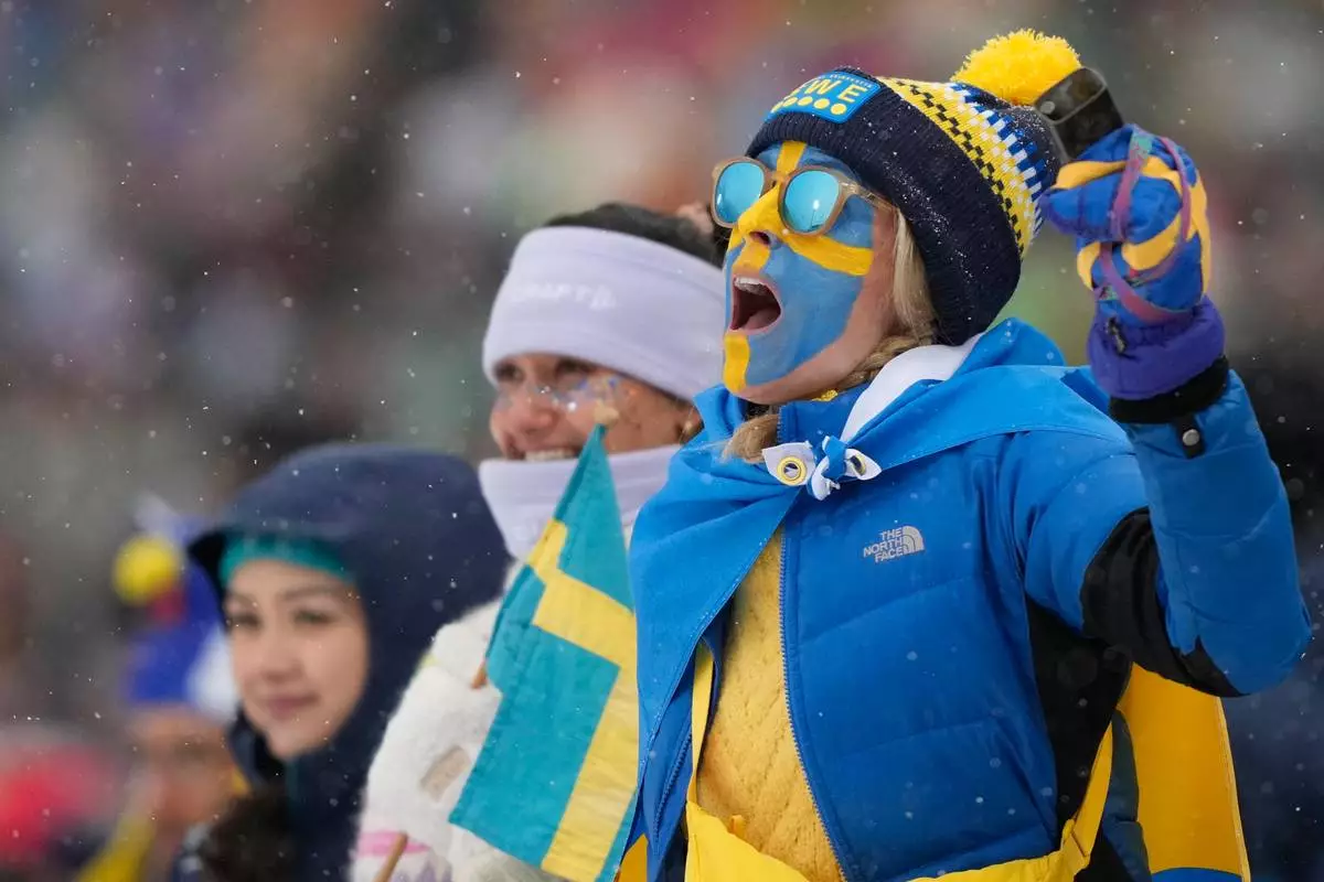 A fan of Sweden reacts as Sweden wins bronze in the men's 4x7.5-kilometer relay biathlon race at the 2026 Winter Olympics in Anterselva, Italy, Tuesday, Feb. 17, 2026. (AP Photo/Mosa'ab Elshamy)