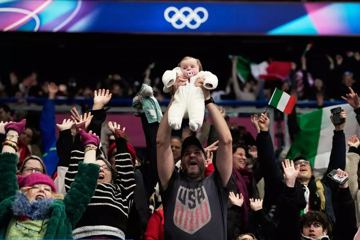 Fans cheer before the figure skating ice dance team event at the 2026 Winter Olympics, in Milan, Italy, Saturday, Feb. 7, 2026. (AP Photo/Natacha Pisarenko)