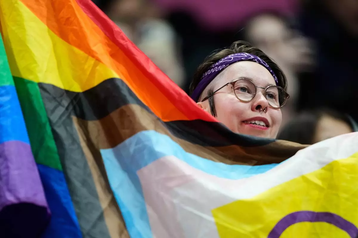 Fans cheer before the women's short program figure skating at the 2026 Winter Olympics, in Milan, Italy, Tuesday, Feb. 17, 2026. (AP Photo/Natacha Pisarenko)