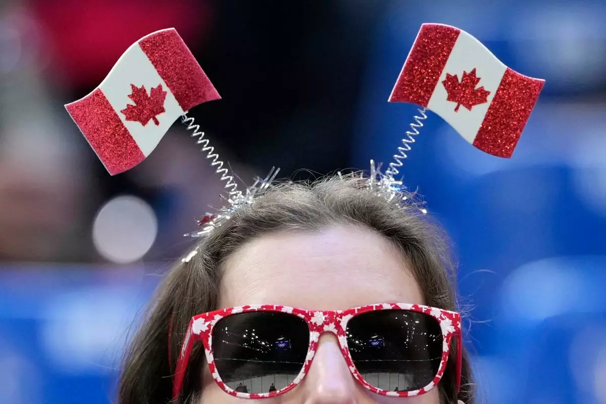 A Canadian fan watches as players warm up before a men's ice hockey qualification playoff game between Czechia and Denmark at the 2026 Winter Olympics, in Milan, Italy, Monday, Feb. 16, 2026. (AP Photo/Hassan Ammar)