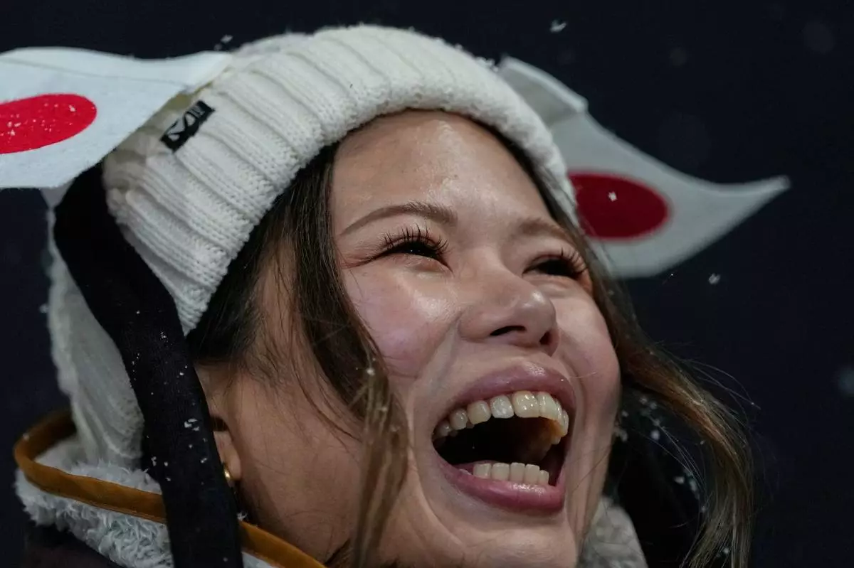 A fan for Japan cheers before the women's snowboarding halfpipe finals at the 2026 Winter Olympics, in Livigno, Italy, Thursday, Feb. 12, 2026. (AP Photo/Julia Demaree Nikhinson)