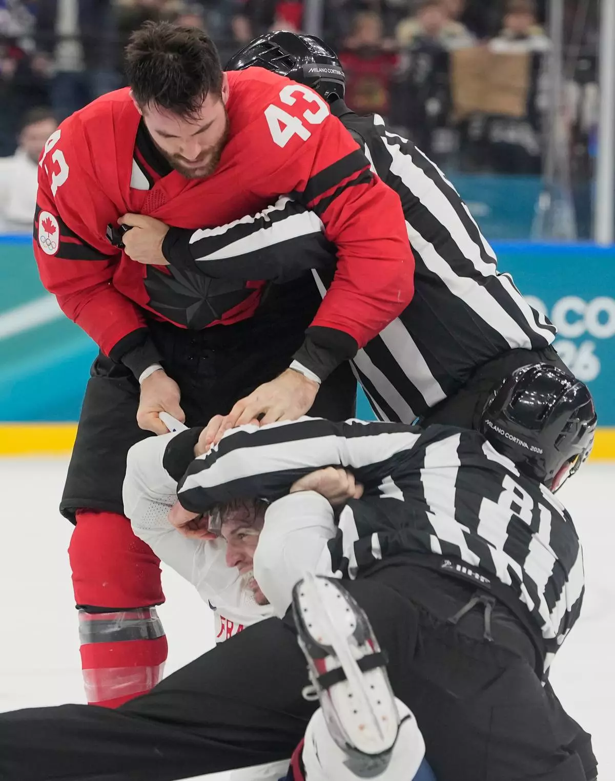 France's Pierre Crinon (7) and Canada's Tom Wilson (43) fight in the third period during a preliminary round game of men's ice hockey between Canada and France at the 2026 Winter Olympics, in Milan, Italy, Sunday, Feb. 15, 2026. (AP Photo/Hassan Ammar)