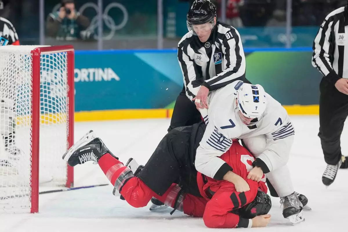 France's Pierre Crinon (7) and Canada's Tom Wilson (43) fight in the third period during a preliminary round game of men's ice hockey between Canada and France at the 2026 Winter Olympics, in Milan, Italy, Sunday, Feb. 15, 2026. (AP Photo/Hassan Ammar)
