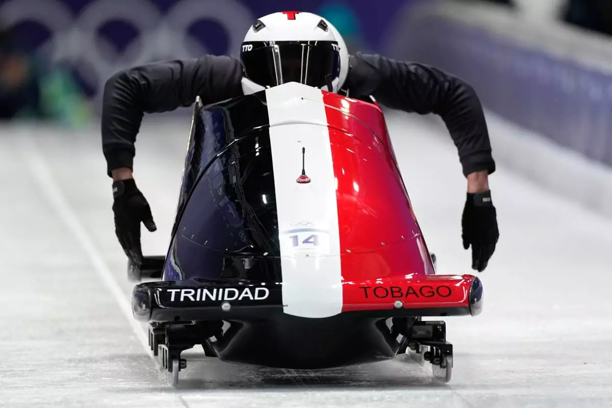 Trinidad And Tobago's Axel Brown, front, starts for a two man bobsled training session at the 2026 Winter Olympics, in Cortina d'Ampezzo, Italy, Thursday, Feb. 12, 2026. (AP Photo/Aijaz Rahi)