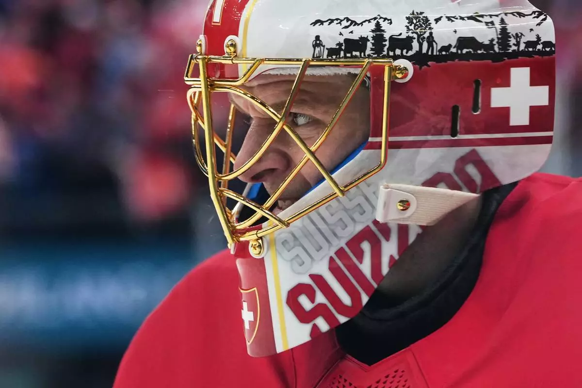 Switzerland's goalkeeper Leonardo Genoni grimaces during a preliminary round match of men's ice hockey between Switzerland and France at the 2026 Winter Olympics, in Milan, Italy, Thursday, Feb. 12, 2026. (AP Photo/Carolyn Kaster)