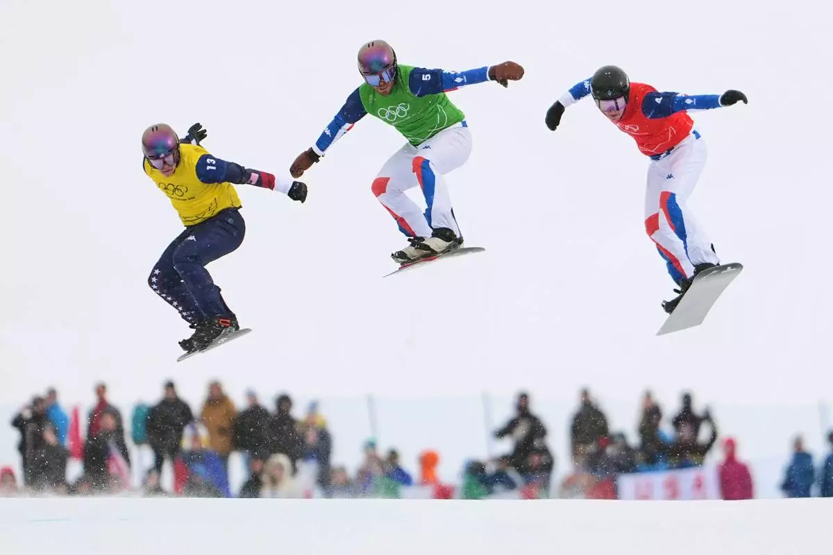 United States' Nathan Pare (13), France's Jonas Chollet (4) and France's Loan Bozzolo (5) compete during the men's snowboard cross finals at the 2026 Winter Olympics, in Livigno, Italy, Thursday, Feb. 12, 2026. (AP Photo/Lindsey Wasson)