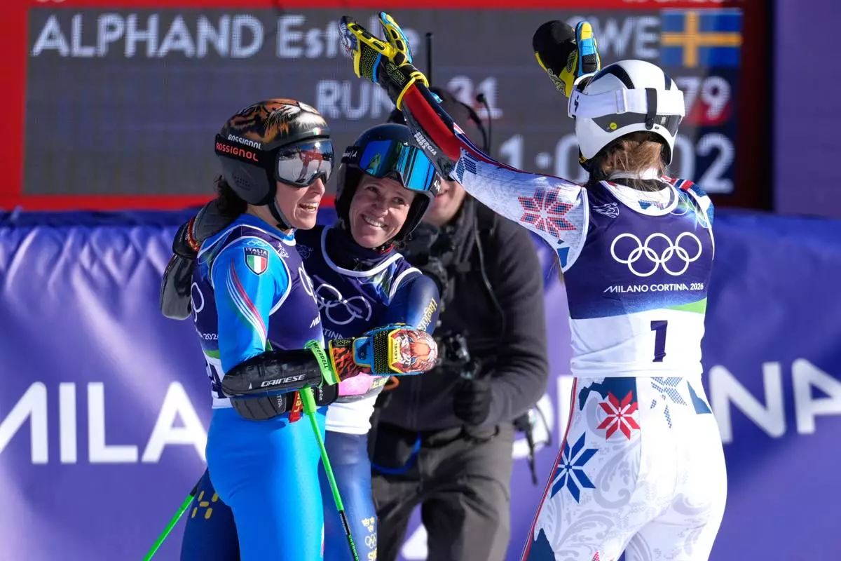 Bronze medalist Norway's Thea Louise Stjernesund, right, and silver medalist Sweden's Sara Hector, center, celebrate with gold medal's winner Italy's Federica Brignone, left, following an alpine ski, women's giant slalom race, at the 2026 Winter Olympics, in Cortina d'Ampezzo, Italy, Sunday, Feb. 15, 2026. (AP Photo/Robert F. Bukaty)