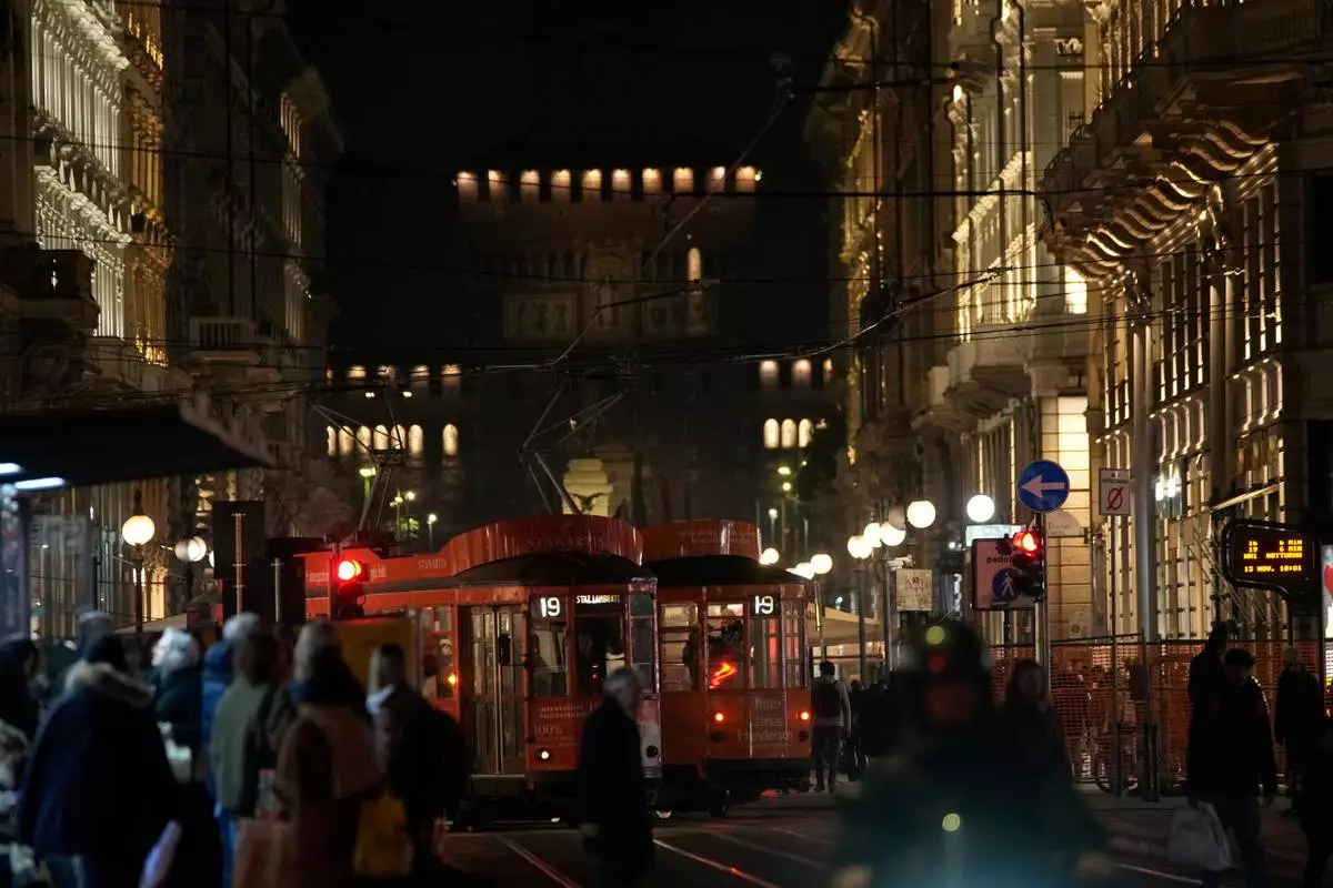 A traditional vintage tram travels on rails through a downtown street, in Milan, Italy, Friday, Nov. 7, 2025. (AP Photo/Luca Bruno)