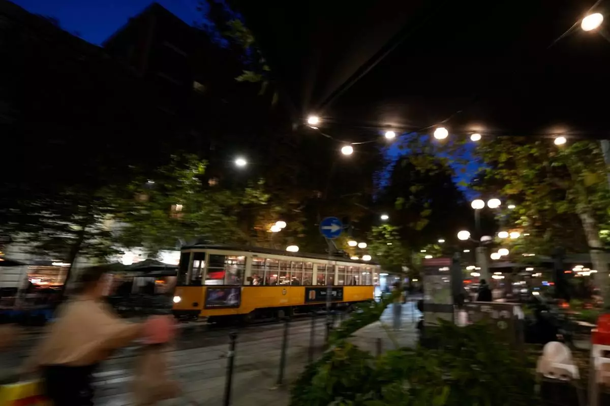 A traditional vintage tram travels on rails through a downtown street, in Milan, Italy, Friday, Nov. 7, 2025. (AP Photo/Luca Bruno)