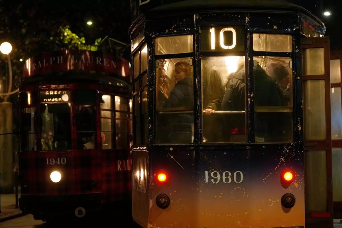 A traditional vintage tram travels on rails through a downtown street, in Milan, Italy, Saturday, Nov. 29, 2025. (AP Photo/Luca Bruno)