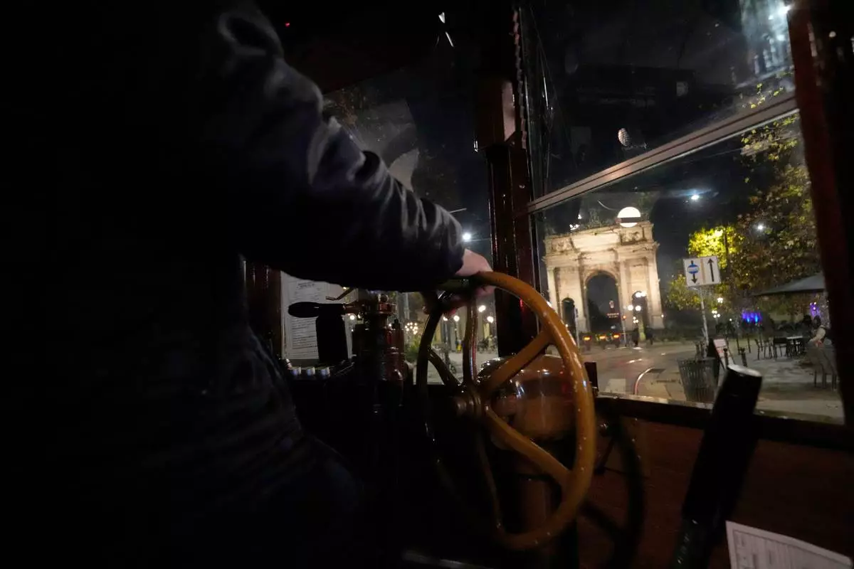 An operator controls command levels of a traditional vintage tram near to the Peace Arch during a Tram tour, in Milan, Italy, Saturday, Dec. 6, 2025. (AP Photo/Luca Bruno)