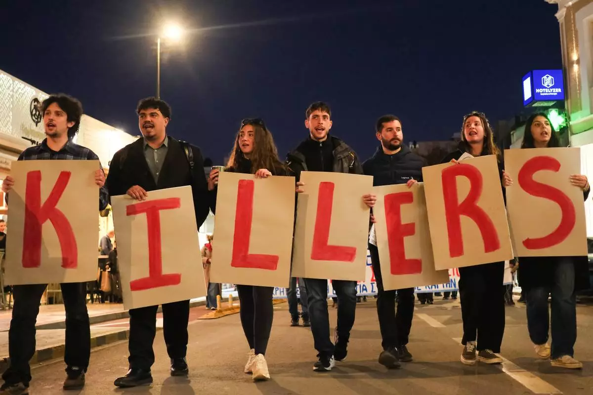 Protesters take part in an anti-war rally in Chania, Greece, opposing the docking of the aircraft carrier USS Gerald R. Ford at the nearby Souda Bay naval base on the southern island of Crete, Tuesday, Feb. 24, 2026. (AP Photo/Giannis Angelakis)