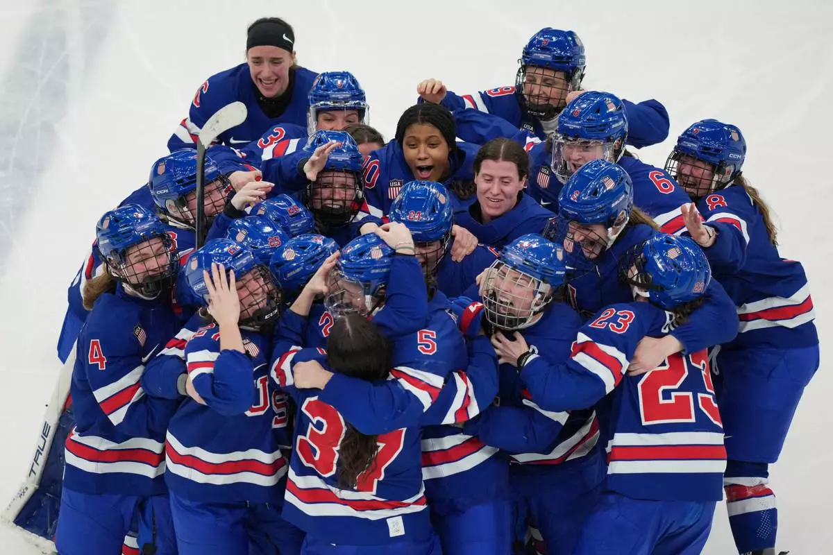 United States players celebrate after beating Canada in overtime to win the women's ice hockey gold medal game at the 2026 Winter Olympics, in Milan, Italy, Thursday, Feb. 19, 2026. (AP Photo/Carolyn Kaster)
