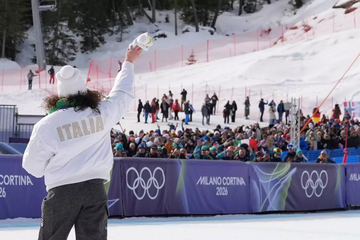 Italy's Federica Brignone, gold medalist in an alpine ski, women's super-G race, waves to supporters at the 2026 Winter Olympics, in Cortina d'Ampezzo, Italy, Thursday, Feb. 12, 2026. (AP Photo/Jacquelyn Martin)