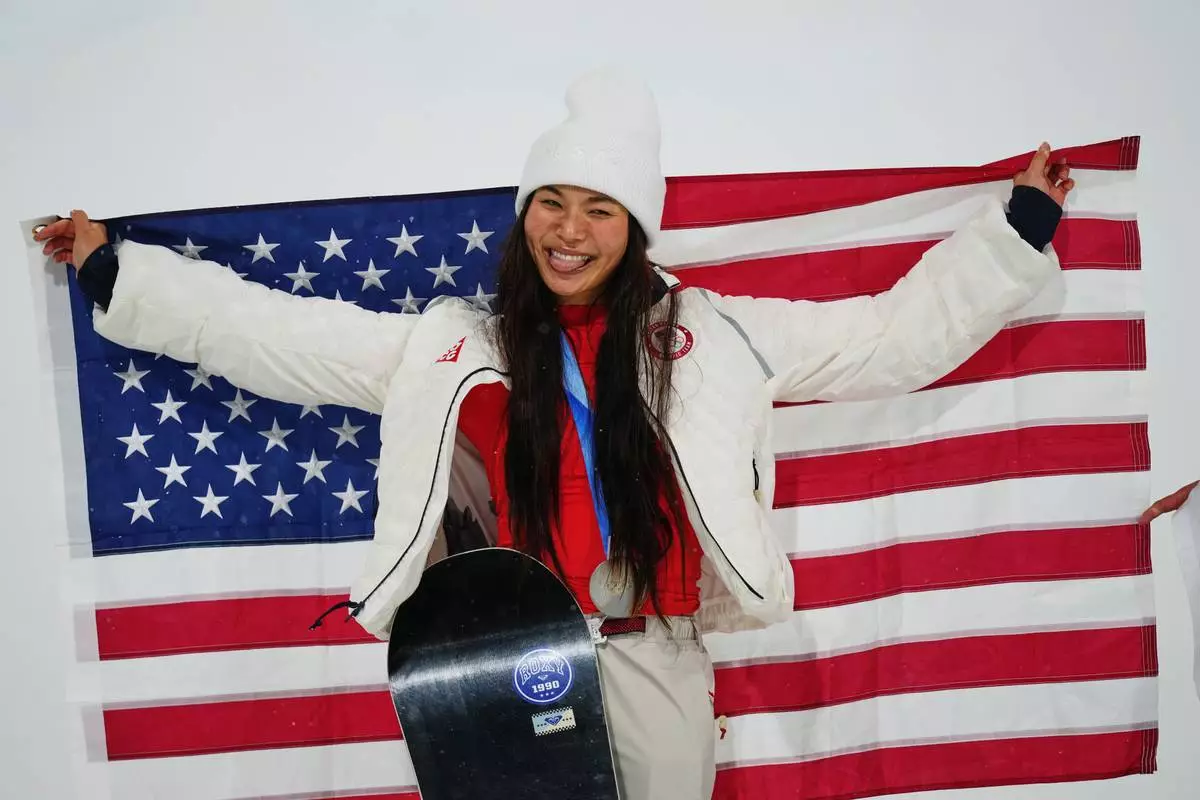 Silver medalist United States' Chloe Kim holds an American flag as she celebrates after the women's snowboarding halfpipe finals at the 2026 Winter Olympics, in Livigno, Italy, Thursday, Feb. 12, 2026. (AP Photo/Abbie Parr)