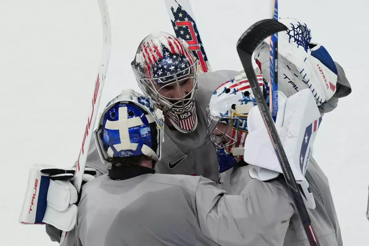 United States goalkeepers Connor Hellebuyck, Jake Oettinger, and Jeremy Swayman, gather on the ice during men's ice hockey practice at the 2026 Winter Olympics, in Milan, Italy, Sunday, Feb. 8, 2026. (AP Photo/Carolyn Kaster)