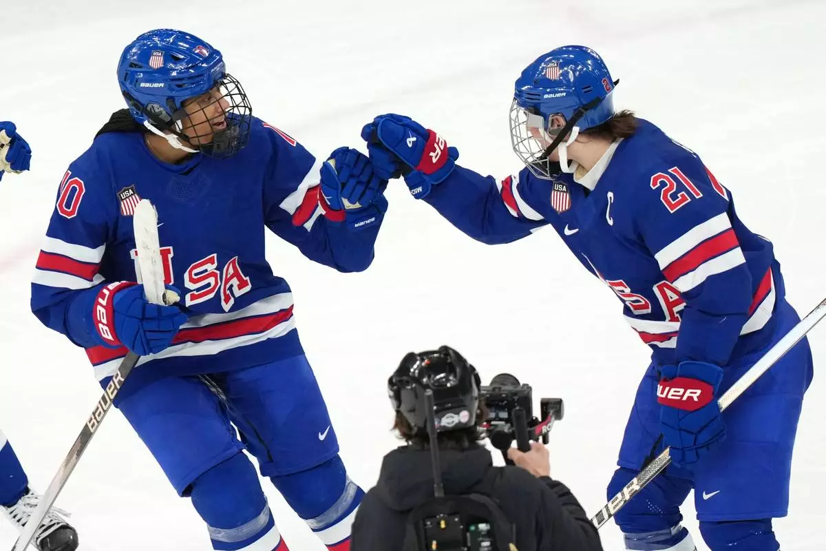 United States' Hilary Knight (21) celebrates with Laila Edwards (10) after Knight deflected a shot by Edwards for a goal against Canada during the third period of the women's ice hockey gold medal game at the 2026 Winter Olympics, in Milan, Italy, Thursday, Feb. 19, 2026. (AP Photo/Carolyn Kaster)