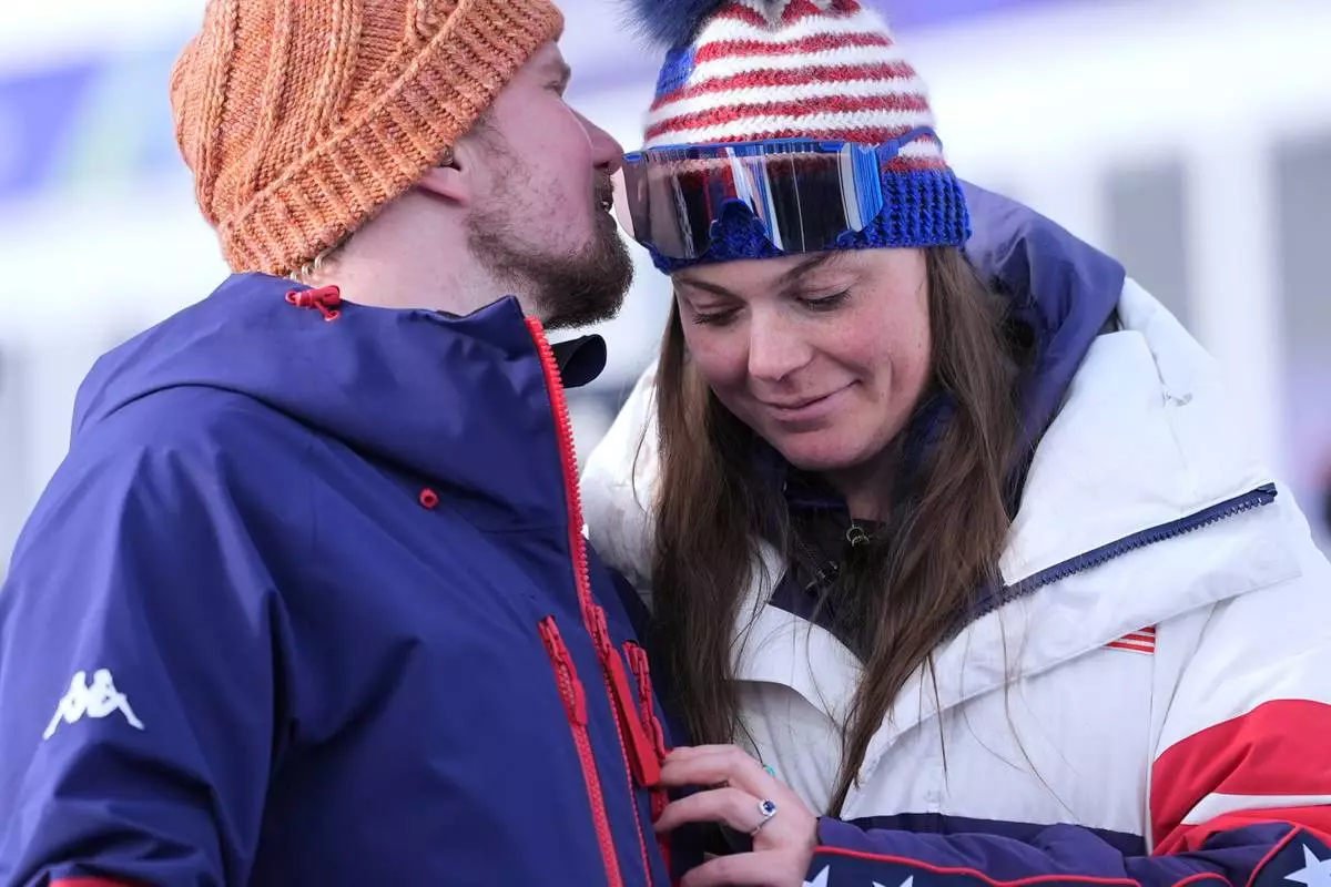 United States' Breezy Johnson, right, and fiancee Connor Watkins are interviewed after he proposed to her at the end of an alpine ski, women's super-G race, at the 2026 Winter Olympics, in Cortina d'Ampezzo, Italy, Thursday, Feb. 12, 2026. (AP Photo/Jacquelyn Martin)