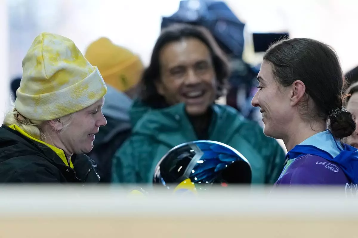 Belgium's Kim Meylemans, left, and Brazil's Nicole Rocha Silveira react, at the finish during a women's skeleton run at the 2026 Winter Olympics, in Cortina d'Ampezzo, Italy, Friday, Feb. 13, 2026. (AP Photo/Alessandra Tarantino)