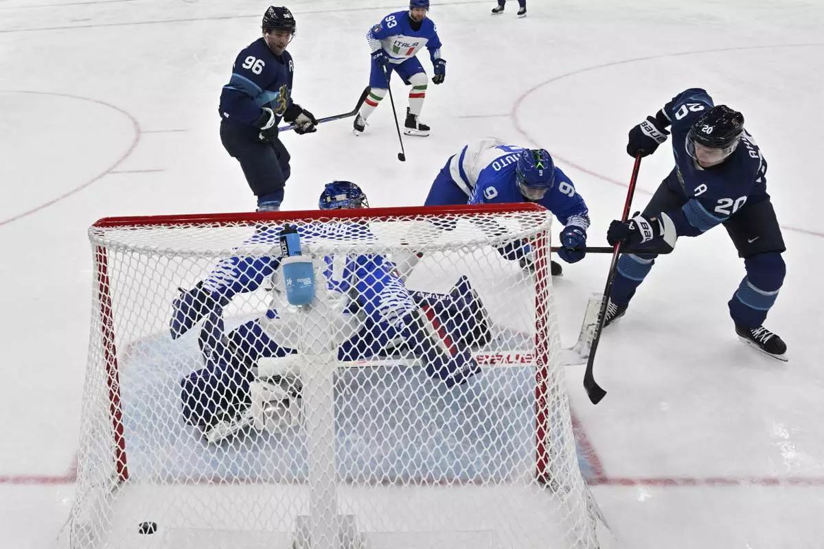 Finland's Sebastian Aho (20) scores his team's first goal during a preliminary round game of men's ice hockey between Finland and Italy at the 2026 Winter Olympics, in Milan, Italy, Saturday, Feb. 14, 2026. (Julien De Rosa/Pool Photo via AP)