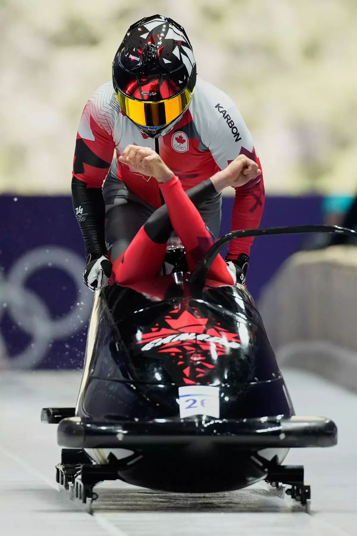 Canada's Taylor Austin, front, and Shaquille Murray-Lawrence start for a two man bobsled run at the 2026 Winter Olympics, in Cortina d'Ampezzo, Italy, Monday, Feb. 16, 2026. (AP Photo/Alessandra Tarantino)