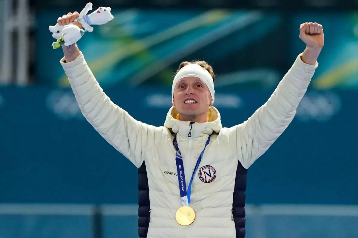 Gold medallist Sander Eitrem of Norway celebrates on the podium after the men's 5,000 meters speedskating race at the 2026 Winter Olympics, in Milan, Italy, Sunday, Feb. 8, 2026. (AP Photo/Ben Curtis)