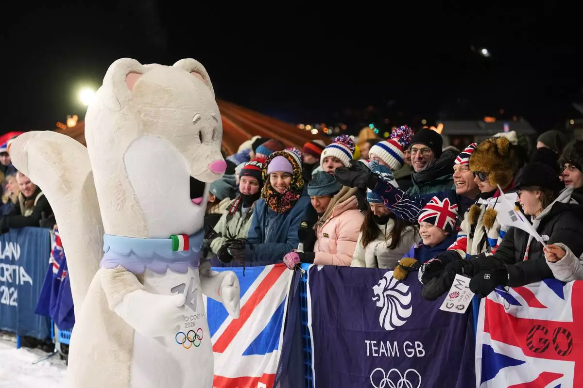 Olympic mascot Tina interacts with fans before the women's snowboarding big air finals at the 2026 Winter Olympics, in Livigno, Italy, Monday, Feb. 9, 2026. (AP Photo/Lindsey Wasson)