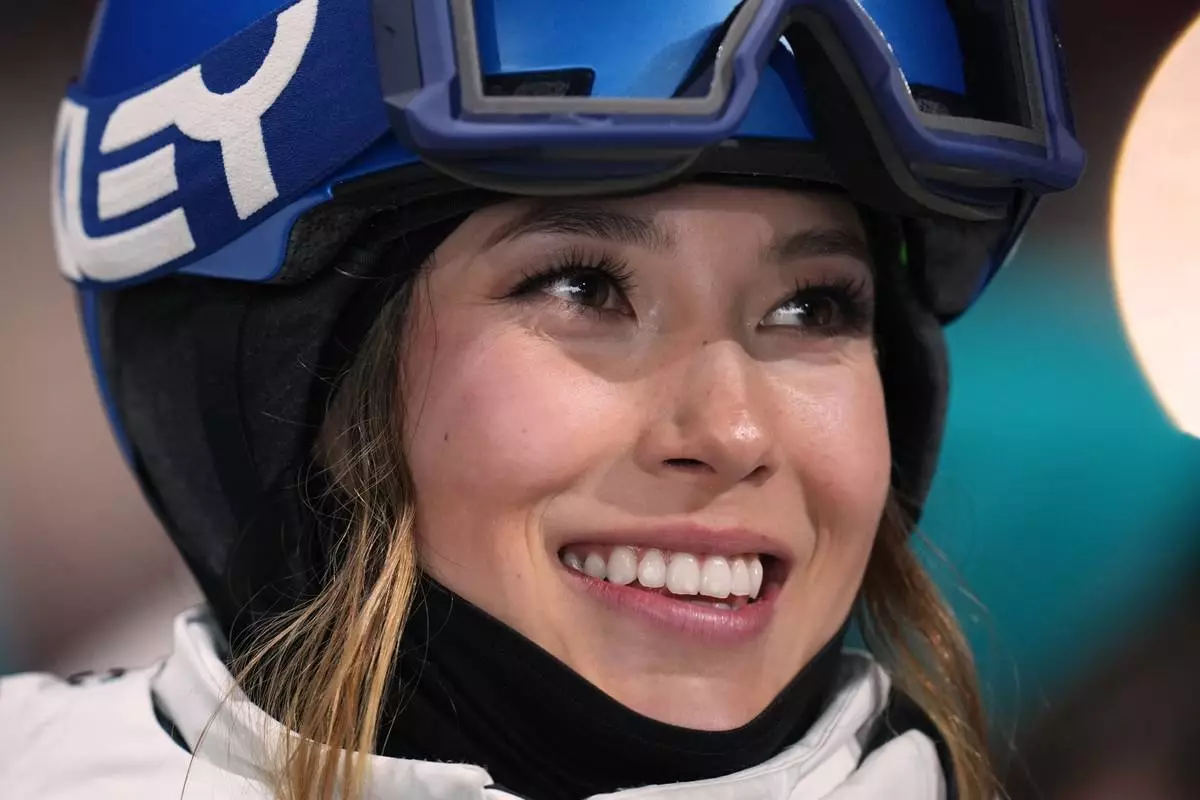 China's Eileen Gu smiles as she waits for her score while competing in the women's freestyle skiing big air qualifications at the 2026 Winter Olympics, in Livigno, Italy, Saturday, Feb. 14, 2026. (AP Photo/Abbie Parr)