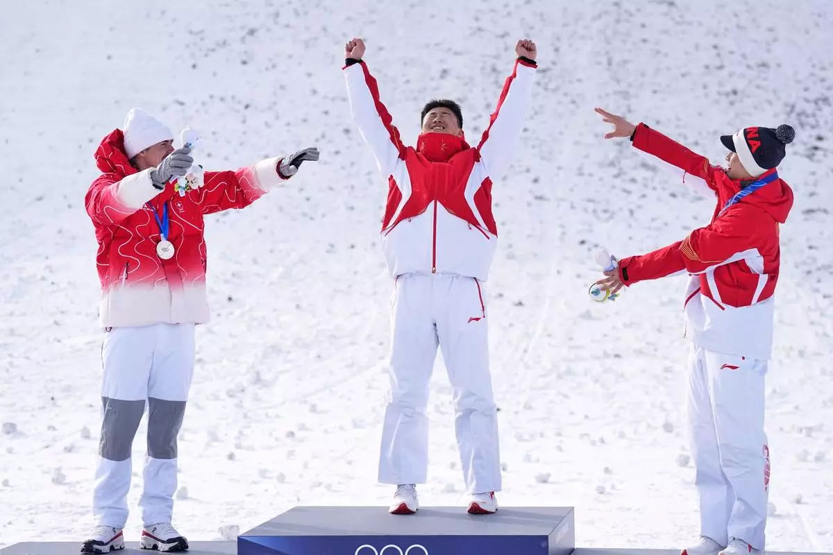 From left, silver medalist Switzerland's Noe Roth, gold medalist China's Wang Xindi and bronze medalist China's Li Tianma celebrate after the men's freestyle skiing aerials finals at the 2026 Winter Olympics, in Livigno, Italy, Friday, Feb. 20, 2026. (AP Photo/Abbie Parr)