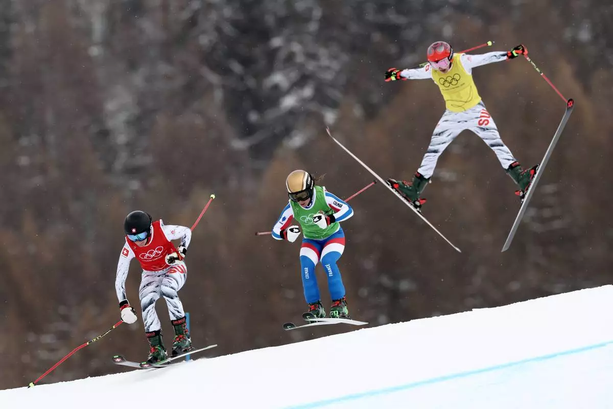 From left, Switzerland's Talina Gantenbein (5), France's Jade Grillet Aubert (6) and Switzerland's Sixtine Cousin (13) compete during the women's ski cross finals at the 2026 Winter Olympics, in Livigno, Italy, Friday, Feb. 20, 2026. (AP Photo/Gabriele Facciotti)