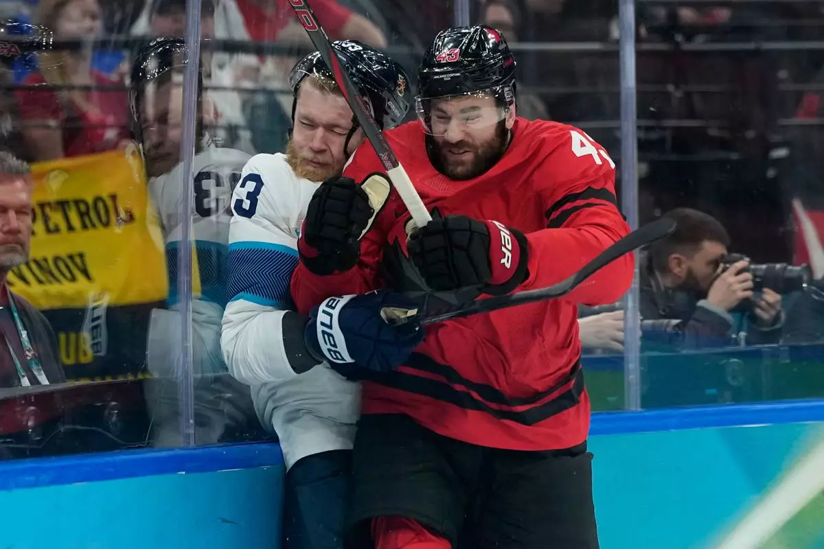 Canada's Tom Wilson, right, challenges with Finland's Nikolas Matinpalo (33) during a men's ice hockey semifinal game between Canada and Finland at the 2026 Winter Olympics, in Milan, Italy, Friday, Feb. 20, 2026. (AP Photo/Petr David Josek)