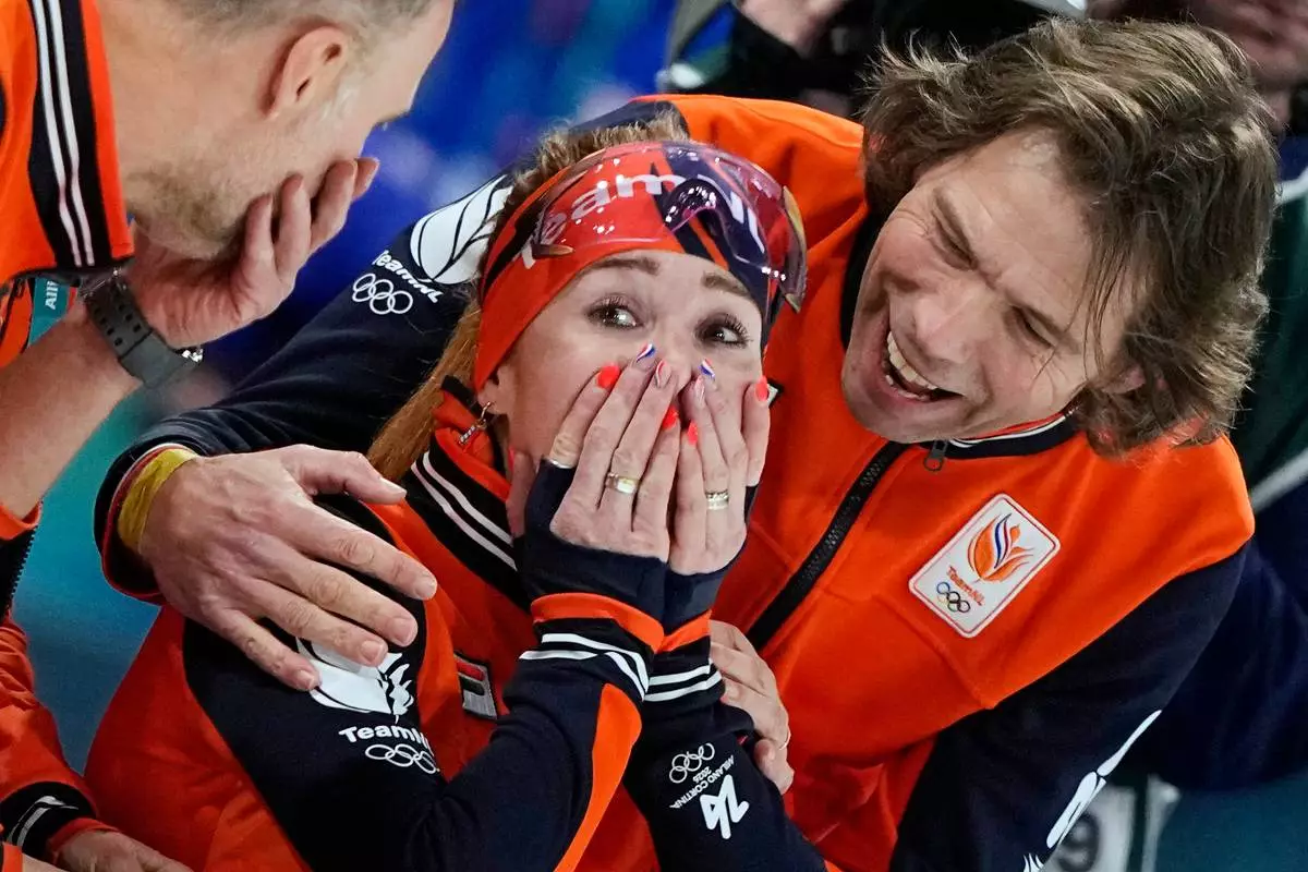 Antoinette Rijpma-de Jong of the Netherlands celebrates winning the gold medal with her coach Gerard van Velde, right, after the women's 1500 meters speedskating race at the 2026 Winter Olympics, in Milan, Italy, Friday, Feb. 20, 2026. (AP Photo/Ben Curtis)