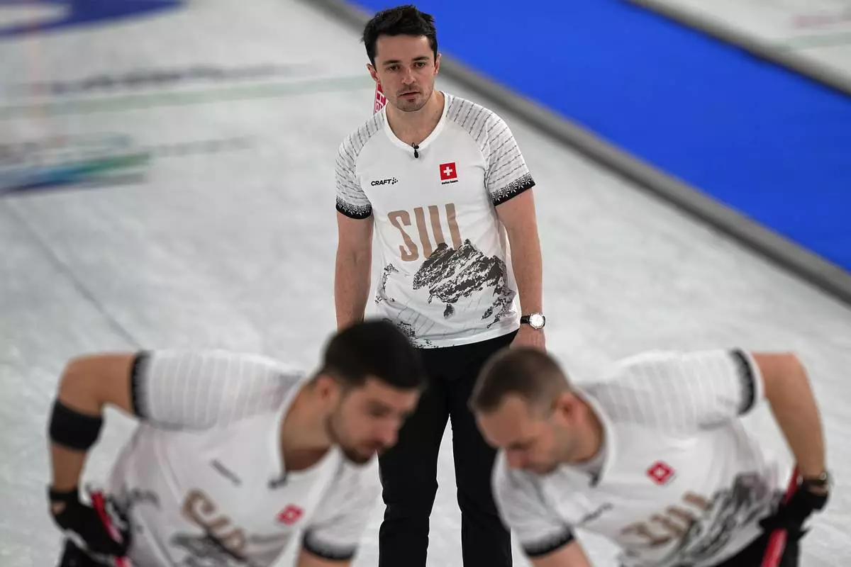 Switzerland's Schwarz-van Berkel Benoit, Sven Michel and Pablo Lachat-Couchepinin action during the men's curling round robin session against Italy at the 2026 Winter Olympics, in Cortina d'Ampezzo, Italy, Thursday, Feb. 19, 2026. (AP Photo/Fatima Shbair)