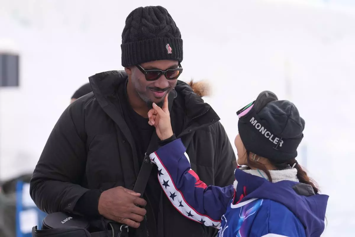 Cleveland Browns' Myles Garrett, left, and United States' Chloe Kim stand after the women's snowboarding halfpipe qualifications at the 2026 Winter Olympics, in Livigno, Italy, Wednesday, Feb. 11, 2026. (AP Photo/Lindsey Wasson)