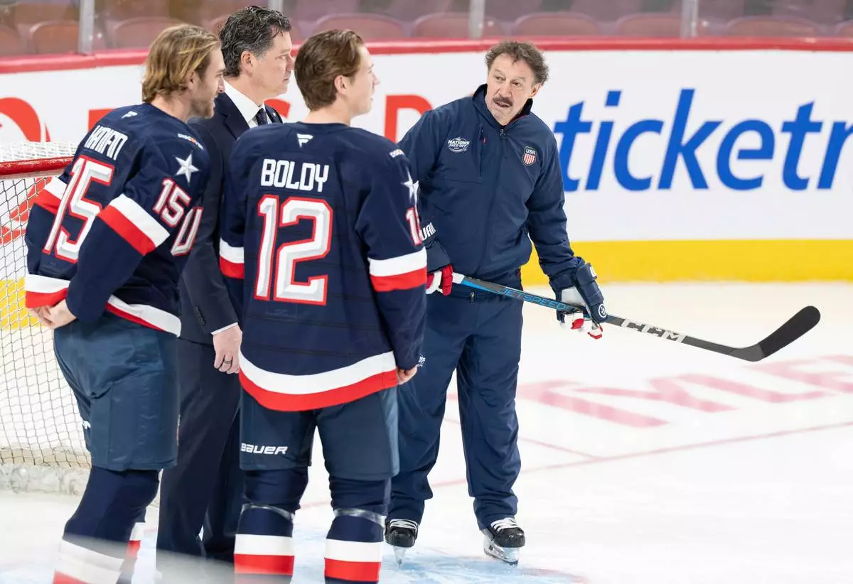 FILE - Guy Gaudreau, right, the father of the late Johnny and Matthew Gaudreau joins U.S.A. team players Noah Hanifin (15) and Matt Boldy (12) on the ice during 4 Nations Face-Off hockey practice in Montreal, Tuesday, Feb. 11, 2025. (Christinne Muschi/The Canadian Press via AP, File)