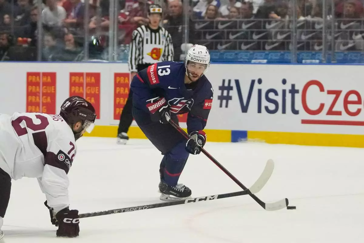 FILE - United States' Johnny Gaudreau, right, challenges for a puck with Latvia's Janis Jaks during the preliminary round match between Latvia and United States at the Ice Hockey World Championships in Ostrava, Czech Republic, Tuesday, May 21, 2024. (AP Photo/Darko Vojinovic, File)