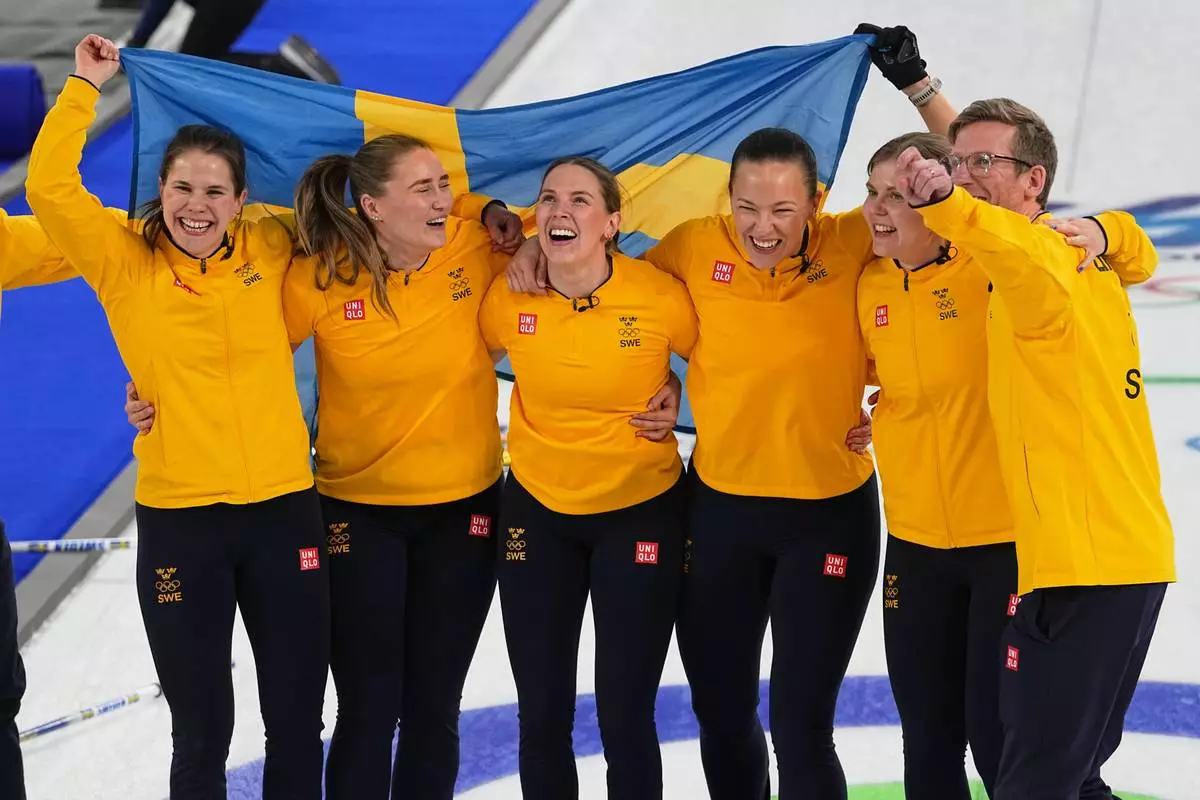 Sweden's Anna Hasselborg, Sara McManus, Sofia Scharback and Agnes Knochenhauer celebrate defeating Switzerland to win a women's curling gold medal match, at the 2026 Winter Olympics, in Cortina d'Ampezzo, Italy, Sunday, Feb. 22, 2026. (AP Photo/Fatima Shbair)