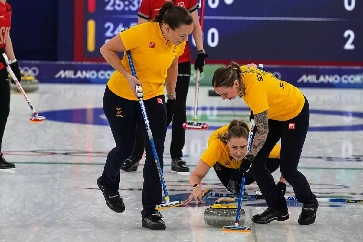 Sweden's Sara McManus, centre, Agnes Knochenhauer, left, and Sofia Scharback compete during a women's curling gold medal match between Switzerland and Sweden, at the 2026 Winter Olympics, in Cortina d'Ampezzo, Italy, Sunday, Feb. 22, 2026. (AP Photo/Fatima Shbair)