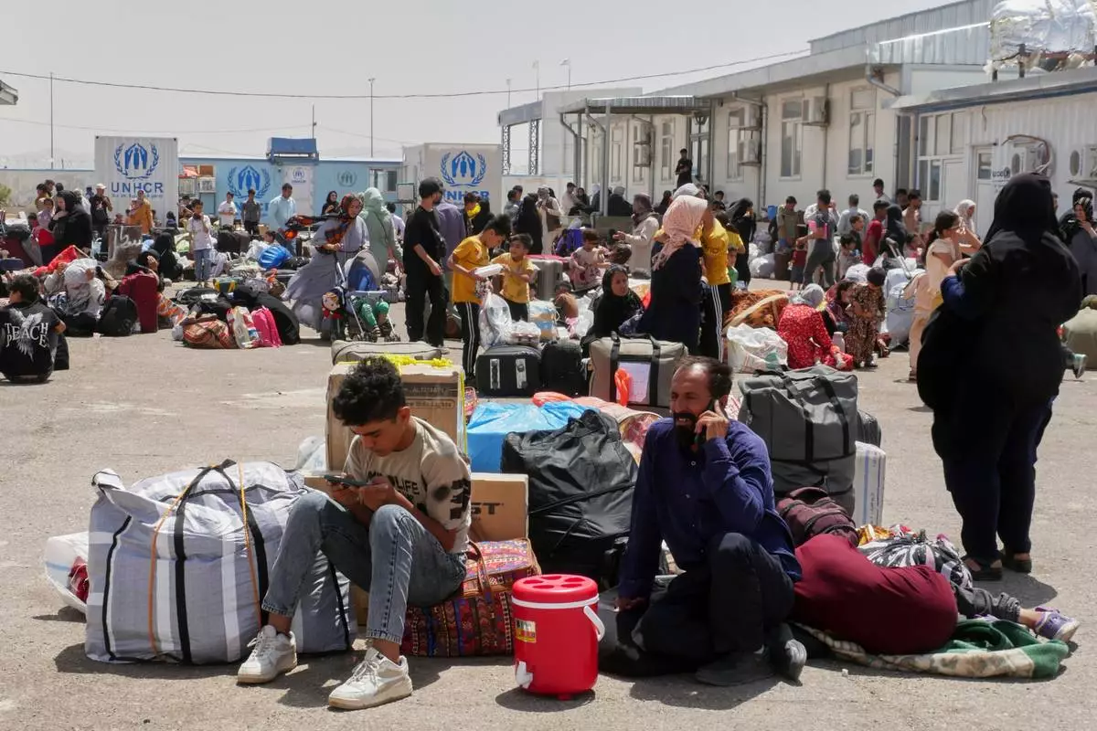 FILE.- Afghan refugees who returned after fleeing Iran to escape deportation and conflict gather at a UNHCR facility near the Islam Qala crossing in western Herat province, Afghanistan, on Friday, June 20, 2025. (AP Photo/Omid Haqjoo,File)