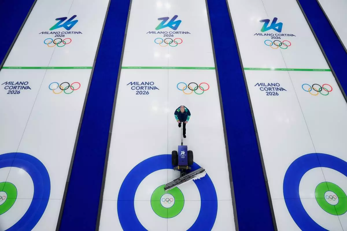Curling ice sheets are prepared ahead of the first competition at the 2026 Winter Olympics in Cortina d'Ampezzo, Italy, Wednesday, Feb. 4, 2026. (AP Photo/David J. Phillip)